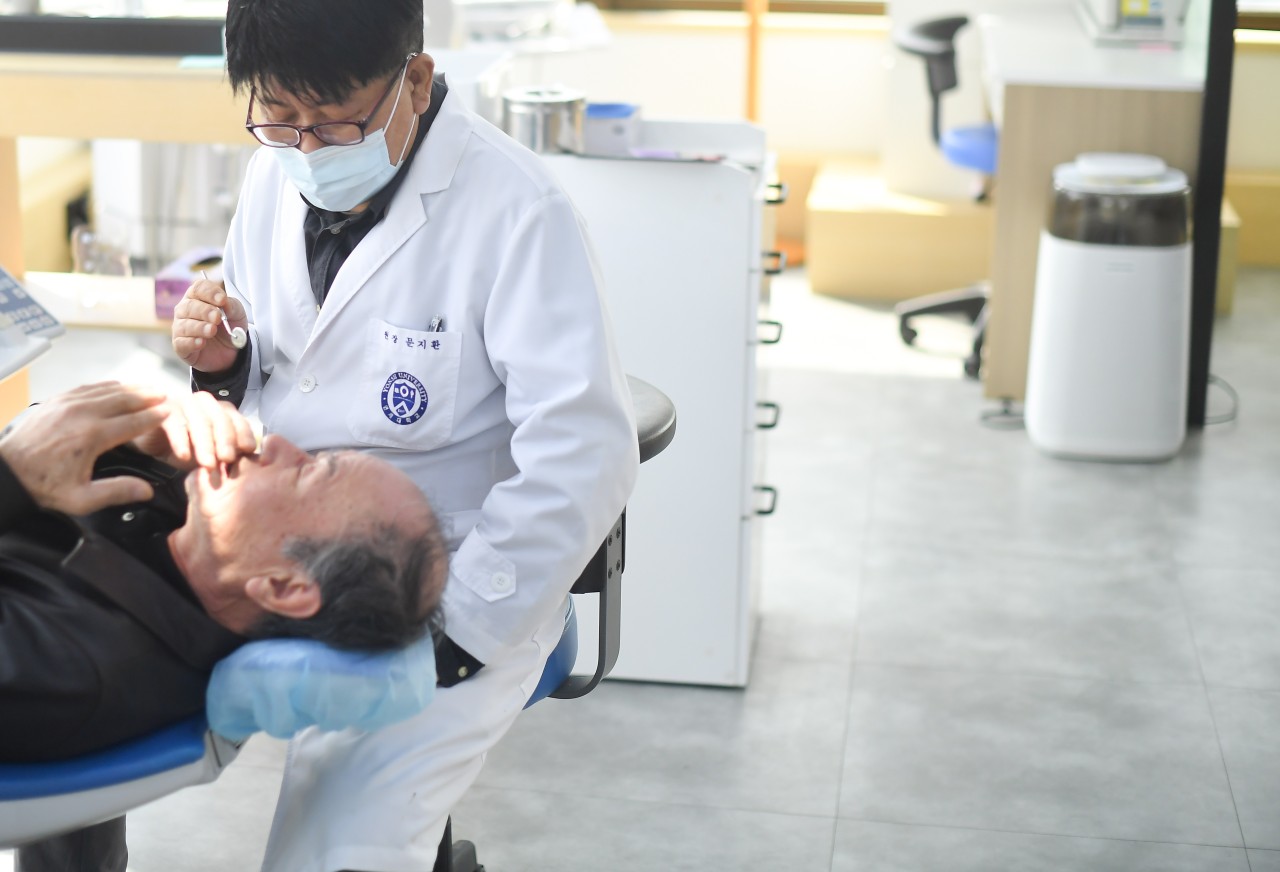 TeulDental dentist examining a senior patient (published with patient consent)